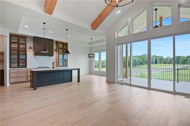 24909 W 98th Pl, Lenexa, KS 66227 - unfurnished living room with light wood-type flooring, beamed ceiling, recessed lighting, a chandelier, and a high ceiling