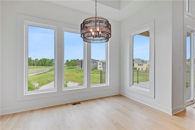 24909 W 98th Pl, Lenexa, KS 66227 - unfurnished dining area featuring light wood finished floors, a chandelier, and plenty of natural light