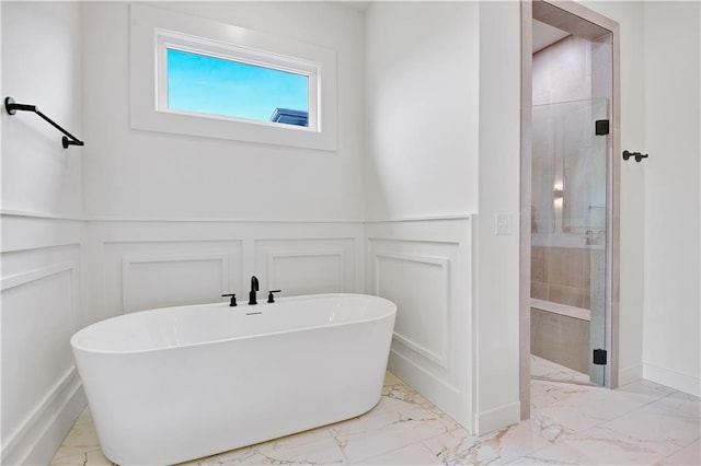 24909 W 98th Pl, Lenexa, KS 66227 - bathroom with marble look tiles, a decorative wall, a freestanding bath, a shower stall, and a wainscoted wall