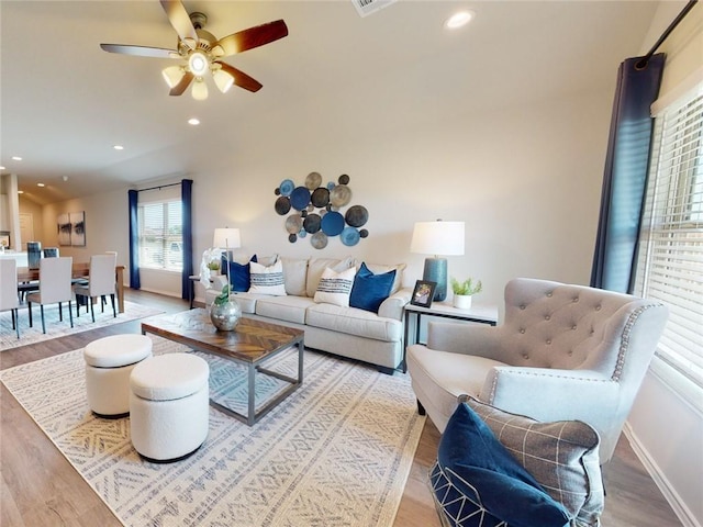 living room with ceiling fan and light hardwood / wood-style flooring