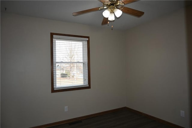 empty room with ceiling fan and dark hardwood / wood-style flooring