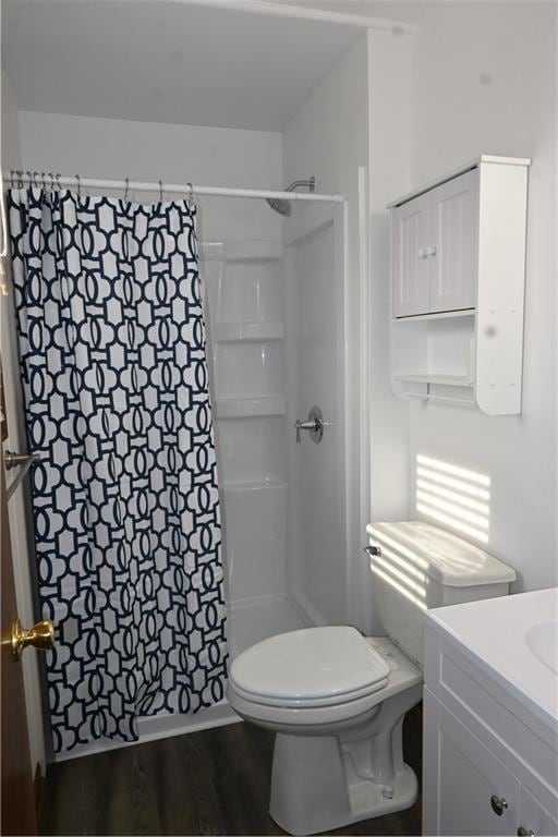 bathroom with toilet, vanity, walk in shower, and wood-type flooring