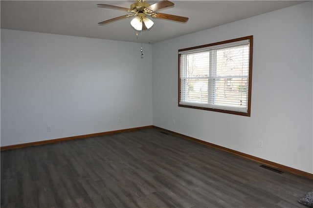 spare room with ceiling fan and dark hardwood / wood-style flooring