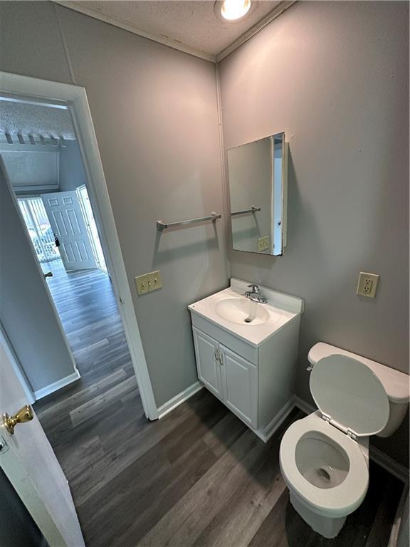 bathroom with vanity, hardwood / wood-style floors, a textured ceiling, and toilet