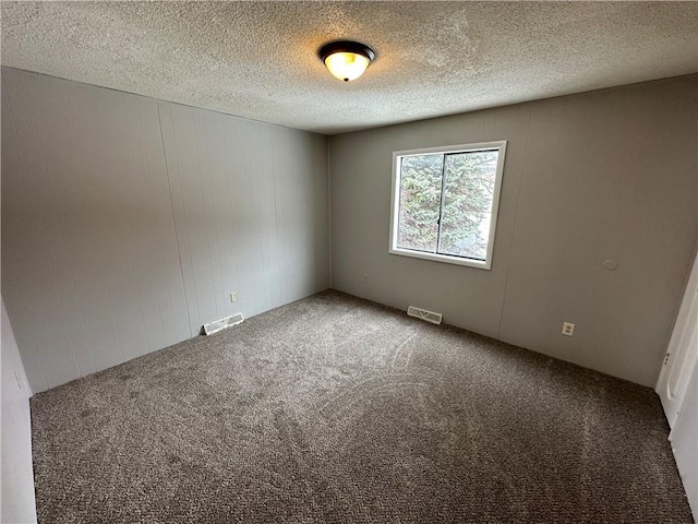 carpeted spare room featuring a textured ceiling