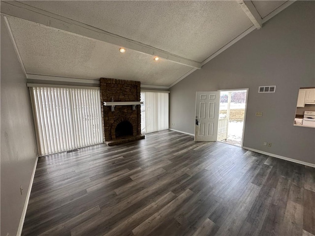 unfurnished living room with dark hardwood / wood-style flooring, beam ceiling, and a textured ceiling