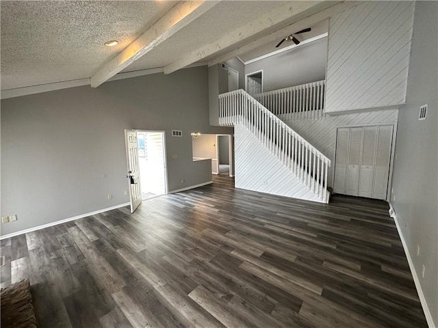 unfurnished living room featuring dark hardwood / wood-style flooring, a textured ceiling, high vaulted ceiling, and beamed ceiling