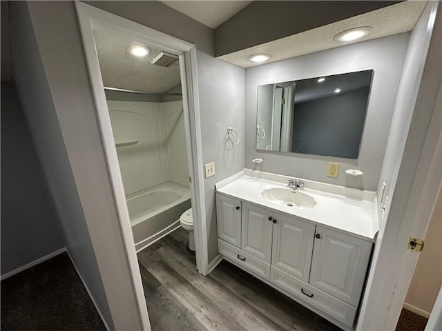 full bathroom with vanity, wood-type flooring, shower / bathing tub combination, and toilet