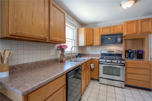 kitchen featuring light tile patterned floors, dark countertops, a sink, black appliances, and backsplash