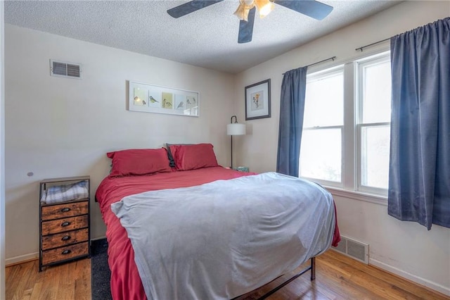 bedroom featuring a textured ceiling, wood finished floors, and visible vents