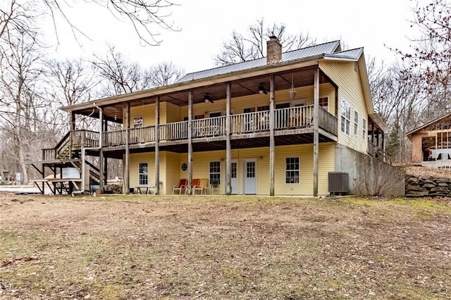 back of property with cooling unit, ceiling fan, and a deck