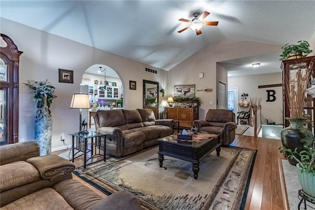 living room with wood-type flooring, vaulted ceiling, and ceiling fan