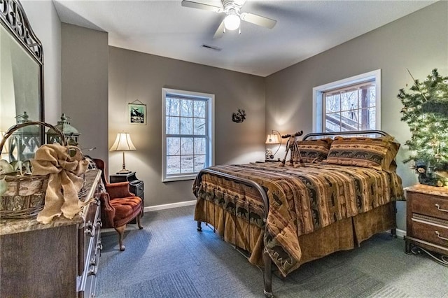 bedroom featuring ceiling fan, carpet floors, and multiple windows