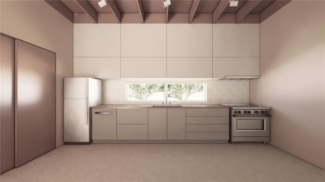 kitchen featuring a sink, freestanding refrigerator, tasteful backsplash, modern cabinets, and high end stainless steel range oven