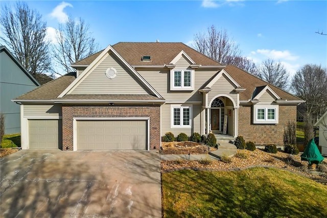 traditional-style house with driveway, brick siding, and an attached garage