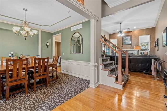 dining area featuring wood finished floors, stairway, decorative columns, and visible vents