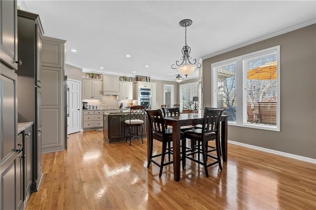 dining room with baseboards, recessed lighting, light wood-type flooring, and crown molding