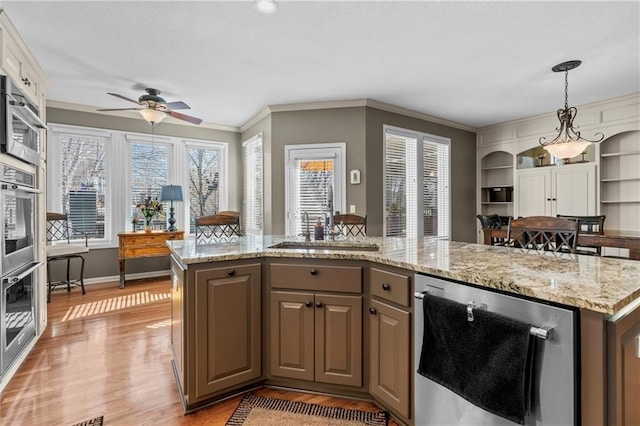 kitchen with light stone countertops, beverage cooler, wood finished floors, a center island, and pendant lighting