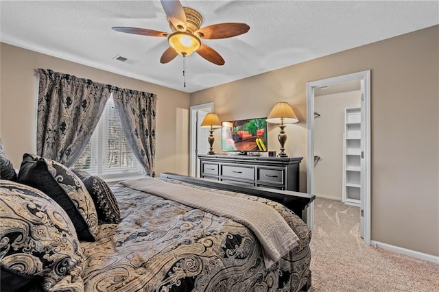 bedroom featuring light carpet, visible vents, baseboards, ceiling fan, and a textured ceiling