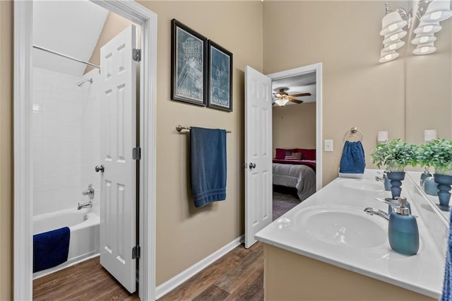 ensuite bathroom featuring  shower combination, ensuite bathroom, a sink, and wood finished floors