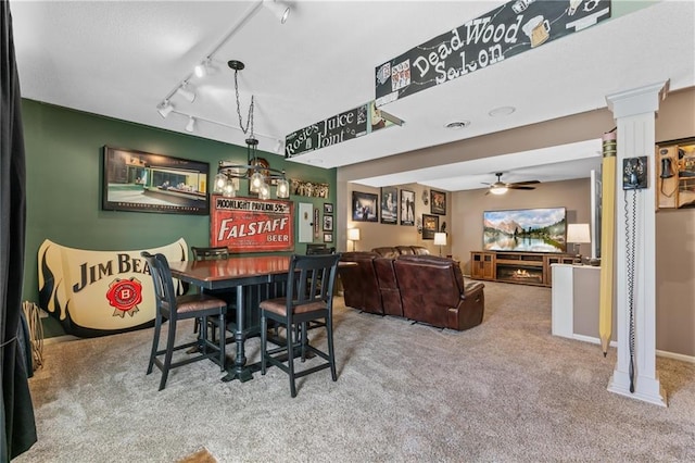 carpeted dining room with baseboards, a ceiling fan, decorative columns, and track lighting