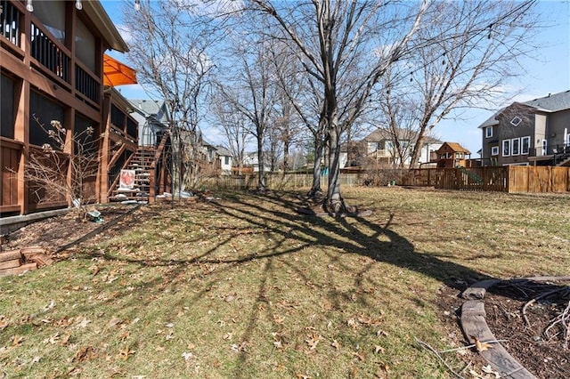 view of yard with a residential view, stairway, and fence