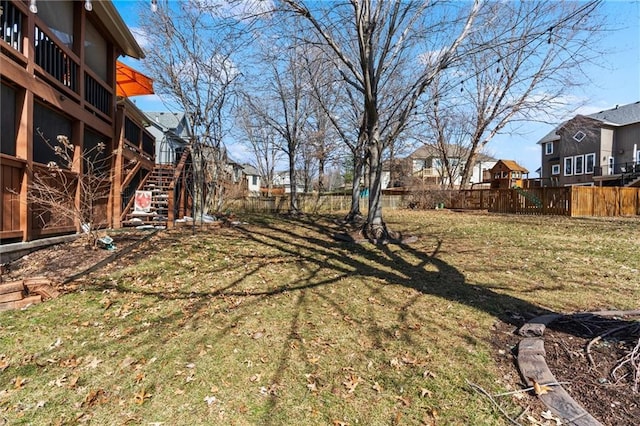 view of yard with stairs, fence, and a residential view