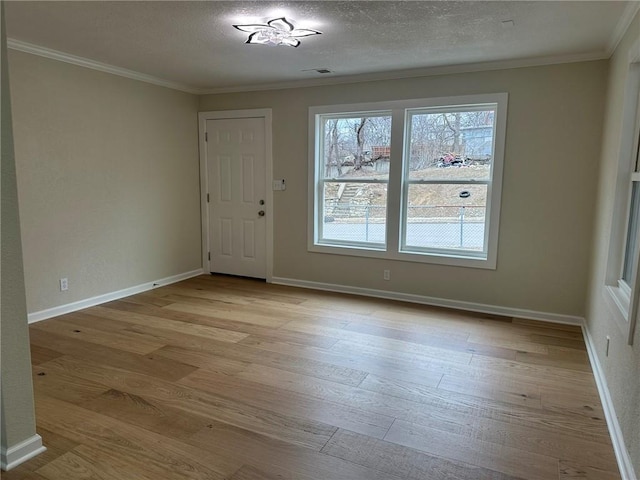 interior space featuring crown molding, light hardwood / wood-style flooring, and a textured ceiling