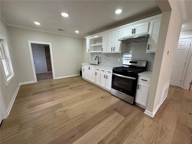 kitchen featuring white cabinetry, light wood-type flooring, decorative backsplash, and stainless steel gas range oven