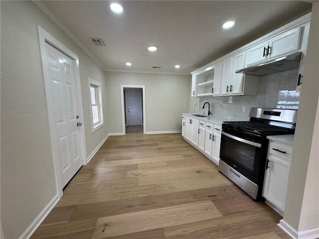 kitchen featuring backsplash, sink, stainless steel range with gas stovetop, and white cabinets