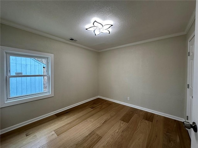 unfurnished room featuring wood-type flooring, ornamental molding, and a textured ceiling