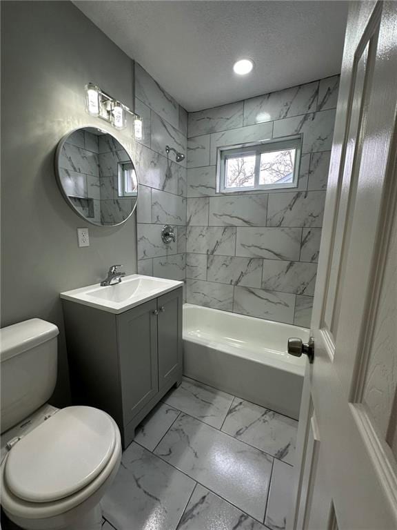 full bathroom featuring tiled shower / bath combo, vanity, a textured ceiling, and toilet