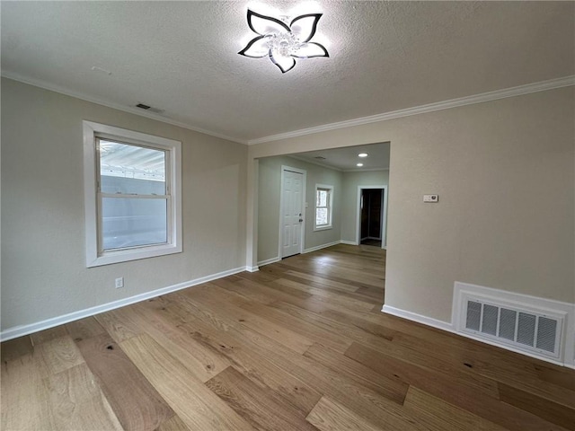 interior space with crown molding, a textured ceiling, and light wood-type flooring