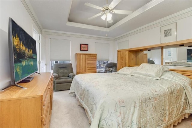 carpeted bedroom with ceiling fan, ornamental molding, and a tray ceiling