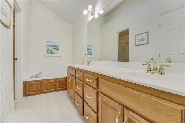 bathroom with vaulted ceiling, vanity, and a bathtub