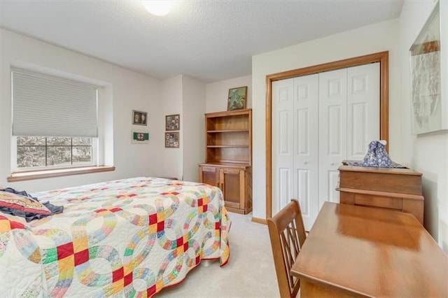 bedroom with a closet, a textured ceiling, and carpet flooring