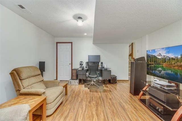 home office featuring hardwood / wood-style floors and a textured ceiling