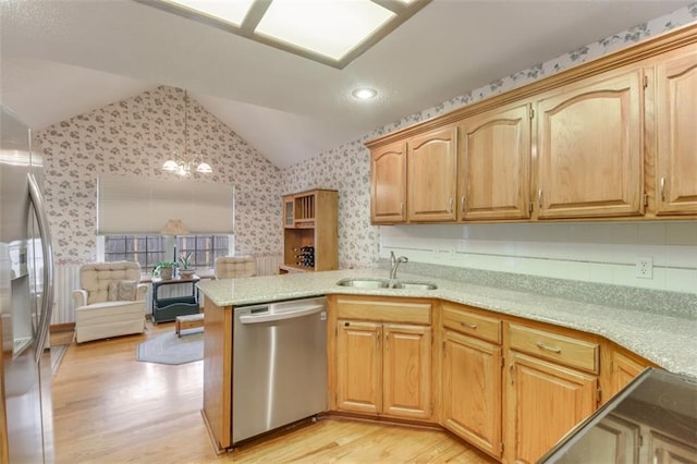 kitchen with lofted ceiling, sink, kitchen peninsula, stainless steel appliances, and light hardwood / wood-style floors