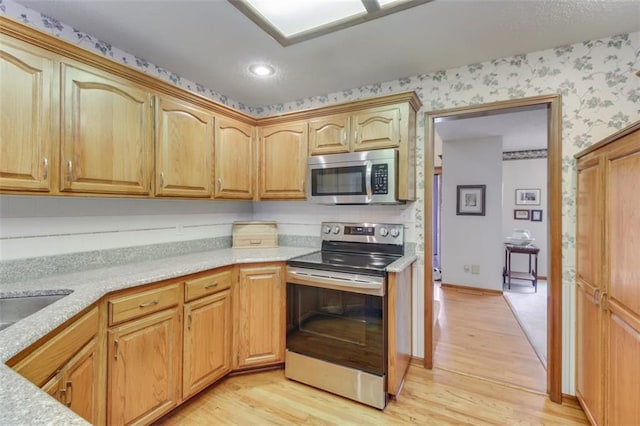 kitchen featuring sink, light wood-type flooring, and appliances with stainless steel finishes