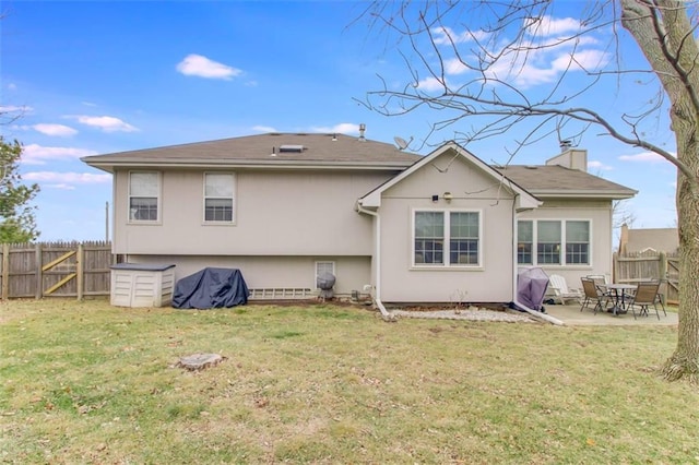 back of property with a patio and a yard