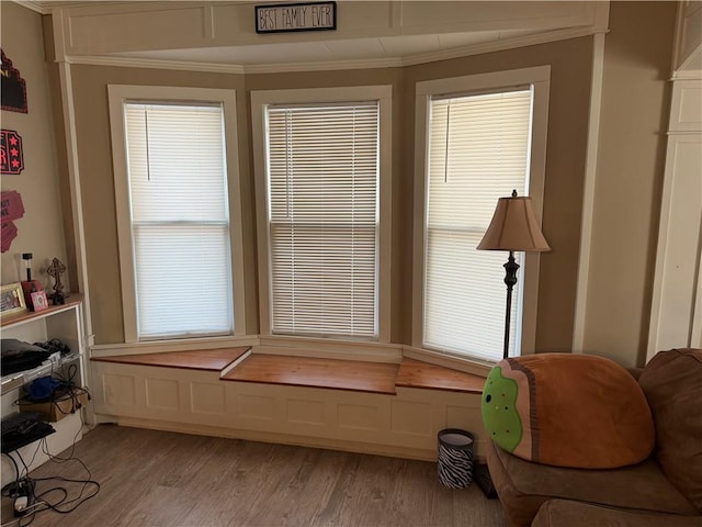 sitting room with ornamental molding and light hardwood / wood-style flooring