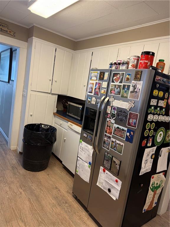 laundry room featuring crown molding and light wood-type flooring