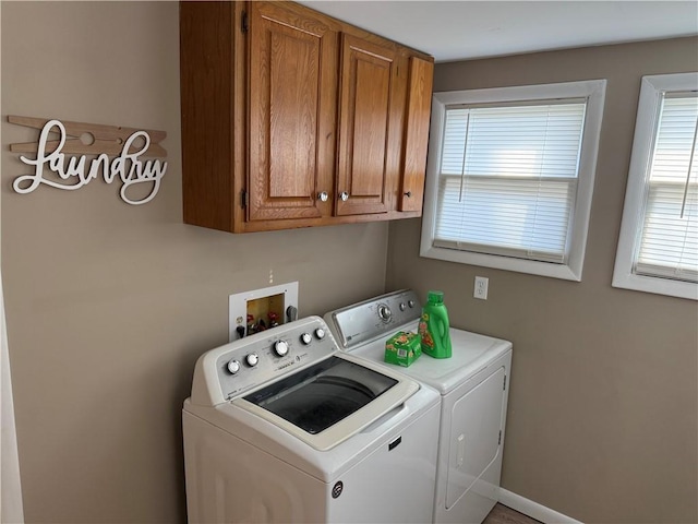 laundry area featuring separate washer and dryer and cabinets