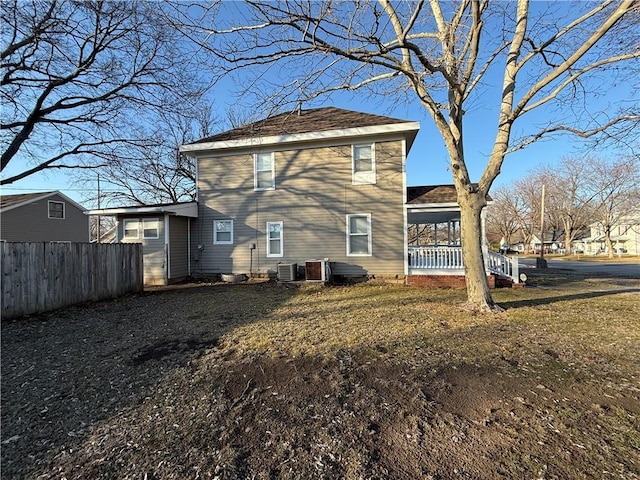 rear view of house featuring a yard and central air condition unit