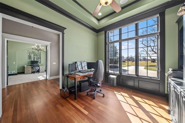 office area with visible vents, crown molding, a tray ceiling, and wood finished floors