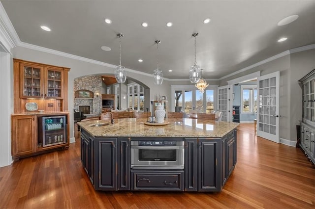 kitchen with oven, wine cooler, a fireplace, french doors, and a sink