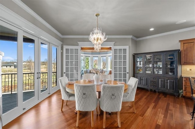 dining room featuring an inviting chandelier, dark wood-style floors, french doors, and crown molding