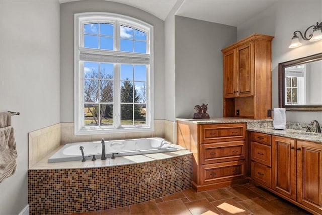 bathroom featuring a bath, vanity, and stone finish flooring