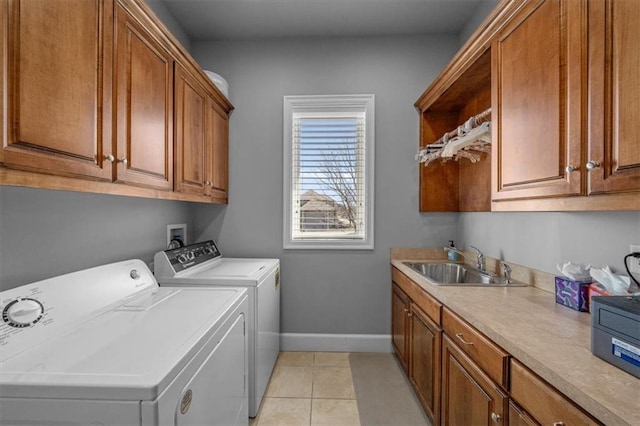 laundry area featuring independent washer and dryer, a sink, cabinet space, light tile patterned floors, and baseboards