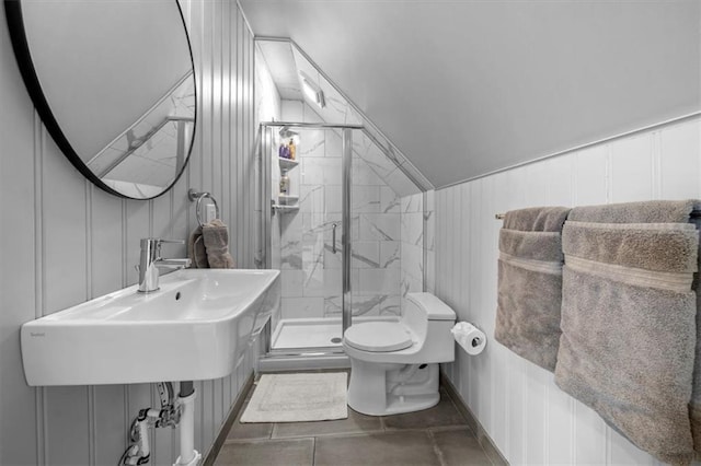 full bathroom with a marble finish shower, toilet, vaulted ceiling, a decorative wall, and a sink